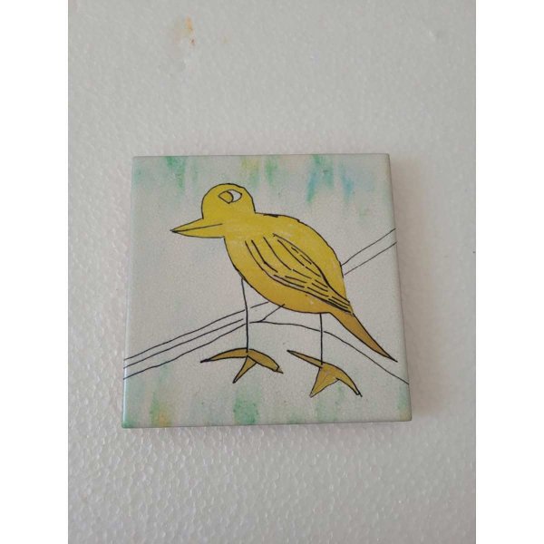 Mattonella in ceramica con uccello giallo